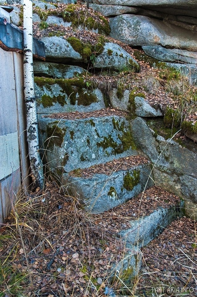 Detail schodiště vyčnívající pod skalním útvarem